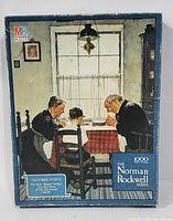 Front of puzzle box showing the image of praying family and branding with 1000-piece count