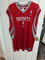Front view of red Houston Rockets NBA basketball jersey with Steven Francis number 3, hung on hanger
