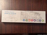 Box of LED digital loud alarm clock with bed shaker sealed and unopened.