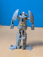 Front view of the 1984 Go-bots Dive Dive robot figure showing arms, torso with colored stickers, and legs with fin details.