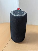 Front view of black cylindrical Monster portable Bluetooth speaker with control buttons visible on the top surface.