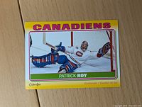 Front of 2012-13 Patrick Roy Montreal Canadiens O-Pee-Chee hockey sticker card showing action image of goalie in white jersey making save.