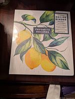 Front cover of recipe binder featuring a lemon and leaf illustration with details of what the binder includes.