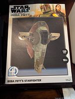 Front side of the box showing image of the assembled Boba Fett Starfighter model and basic details (130 pieces, age 10+).