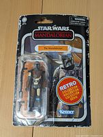 Front view of unopened Star Wars The Mandalorian Retro Collection action figure in original packaging with visible character figure and branding.