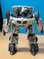 Front view of the Transformers Jazz figure showing white and black robot with car detailing, head sculpt, and wheels on legs.