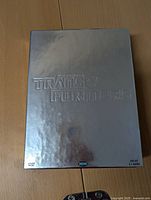 Front of the reflective silver box featuring embossed Transformers logo.