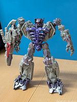 Front view of the Shockwave figure showing the grey and purple color scheme with red weapon accent and detailed robotic features.