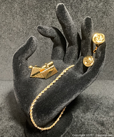 Display of the three jewelry pieces on a black mannequin hand including the 14k yellow gold rope chain and two pairs of cuff links.