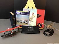 Two diecast aircraft models with accompanying books and memorabilia arranged on a surface.