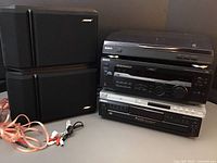 Photo showing five-piece audio visual setup with Sony turntable top, AV receiver, Magnavox DVD/CD player, Sony CD changer underneath, and Bose speakers to side with wires.