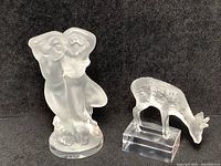 Two Lalique crystal figurines side by side against a black background, showing size and sculptural details