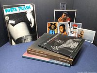 Books and signed pop art prints including White Trash, Tao of Photography, Sweet Life, and others, with some damage visible on books