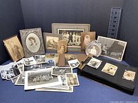 Full lot overview showing all framed photos, loose prints, and scrapbook album.