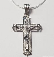Close-up image of the 10K gold crucifix cross pendant showing the detailed Jesus figure and decorative edges against a white background.