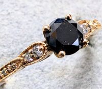 Close-up front image of the ring showing black diamond center and lab diamonds on band.