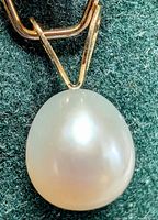 Close-up of 14K yellow gold fresh water pearl pendant showing the natural white pearl and gold bail.