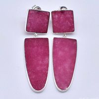 Front view of the earrings showing pink chalcidoney stones set in silver, one large trapezoid shape below a smaller square stone per earring.