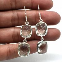 Close-up of two silver green amethyst dangle earrings held in hand showing stone clarity and cut.