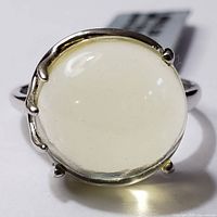 Top down view of the round lemon quartz gemstone set in polished silver ring with claw-style prongs.