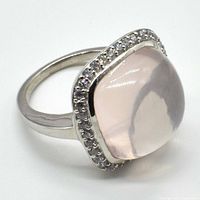 Silver ring displaying a cushion-shaped rose quartz centered within a border of small clear stones.