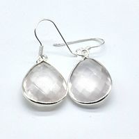 Top view of two silver earrings with pear-shaped translucent rose quartz stones and silver hooks.