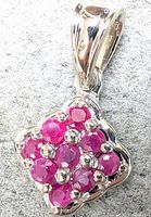 Front view of silver pendant with clustered natural ruby stones