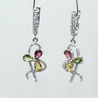 Close-up of matching drop earrings showing pink, green, and yellow pear-shaped tourmaline stones with clear stone accents in silver.