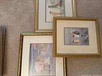 Photo showing the three framed art prints on carpet with their images visible