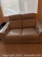 Front view of light grey leather loveseat in upright position