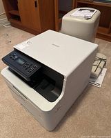 Brother printer at front and beige Royal paper shredder behind with loose manual.