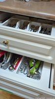 Drawer of assorted kitchen utensils including peelers and other tools