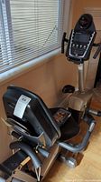 Side view of Schwinn recumbent bike showing padded seat with backrest and part of the digital console display.