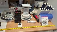 Wide view of the lot on a countertop showing various kitchen accessories including scales, rice cooker, grater, and knife block with knives
