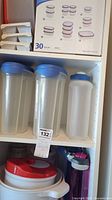 Plastic storage containers set and pitchers with blue lids on shelf