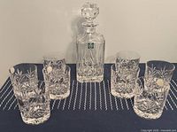 Full set of one decanter and eight glasses on table