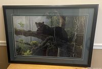 Front view of the framed picture showing a black panther on a tree branch in a forest scene.