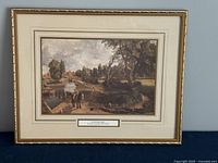 Full view of framed print titled 'Flatford Mill' by John Constable, showing a river scene with people and trees under a gold-tone frame.