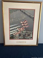 Framed print showing Snowbirds aircraft in formation over river and bridge, with aerial city view.