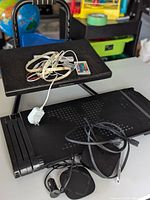 Apple TV device with ports visible, adjustable office footrest and side desk, LED strip light remote control and white charger cables