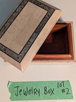 Closed view showing cream stone-like textured exterior and gray stone border on box lid.