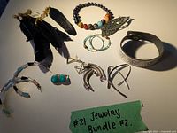 Full view of earrings and bracelets including feather earrings, colorful bead bracelet, turquoise hoop earrings, silver-tone metal earrings, and chunky bangle bracelet.