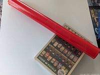 Photo of the rolled red puzzle mat and puzzle box showing the full box cover image