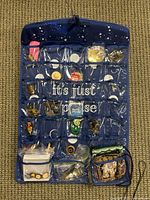 Blue star jewelry hanger side with various metal-tone miscellaneous craft items in clear pockets