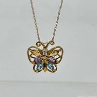 Close-up front view showing butterfly shape and multicolor gemstones