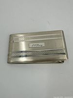Closed view of the rectangular sterling silver cigarette case showing brushed finish and engraved nameplate.