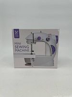 Front view of the original box with image of white and purple mini sewing machine