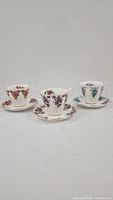 Three Royal Albert teacups with matching saucers from the Dainty Dina series, each featuring distinct floral patterns.