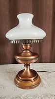Full view of the vintage copper hurricane lamp with white glass shade showing overall design and size.