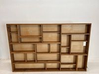 Full front view of the wooden multi-tier shelf showing all compartments.